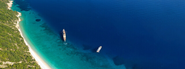Naklejka premium Aerial drone top down ultra wide photo of luxury yacht anchored in tropical exotic island turquoise sea