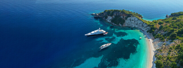 Aerial drone top down ultra wide photo of luxury yacht anchored in tropical exotic island turquoise...