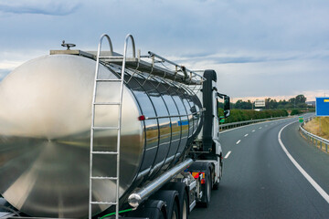Steel tank truck driving on the highway, side view.