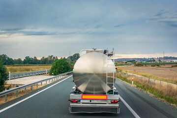 Steel tank truck driving on the highway, rear view.