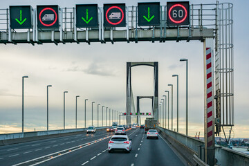 Vehicles circulating on a suspension bridge, with illuminated panels warning of the prohibition of...