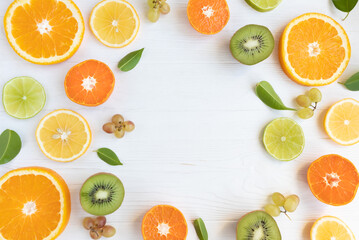 Citrus fruits and kiwi cut into circles, grapes on a white background with space for text. Poster, banner, article.