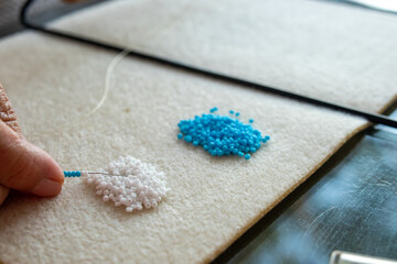 woman hands picking beads for making beaded jewelry