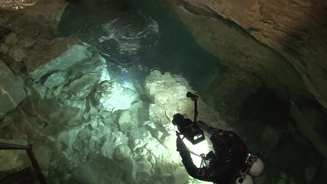 In a small, shallow underground lake located at the very bottom of an airy karst cavity, speleodivers are preparing for a long dive into the Orda underwater cave.
