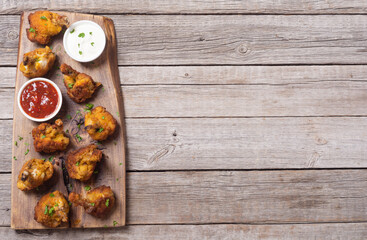 Chicken wings nuggets with sauces on wooden background .