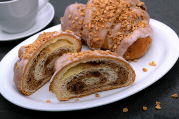 Tasty traditional polish croissants  - Croissant of Saint Martin (Rogal Swietomarcinski) with white poppy seeds, nuts and cup of coffee on a dark slate stone