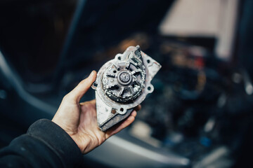 old oxidized rusty water pump of a car in the hands of a mechanic.
