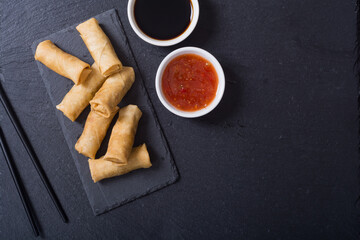 Fried spring rolls with vegetables on rustic background