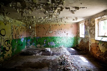An old room with graffiti and cracked plaster in an abandoned military soviet base in Milovice in Czech Republic.