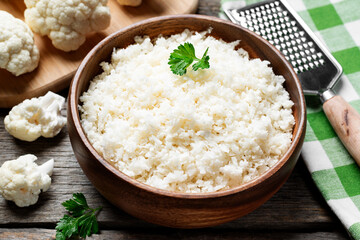 Freshly grated raw cauliflower rice in wooden bowl