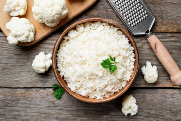 Freshly grated raw cauliflower rice in wooden bowl