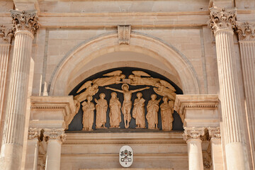 Basilica of Saints Cosmas and Damian in Alberobello in Italy. Stone carvings above entrance door.