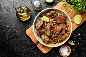 Fried chicken liver with onions and herbs. top view