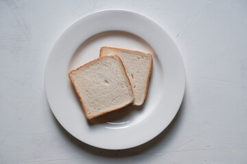Sliced toast bread isolated on the white plate and white background. Horizontal composition