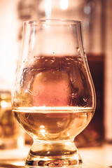 Selective focus glasses of whiskey on rustic wood background, Alcohol drink whiskey or bourbon with ice cubes on wood table together while at bar counter in the pub.