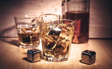 Selective focus glasses of whiskey on rustic wood background, Alcohol drink whiskey or bourbon with ice cubes on wood table together while at bar counter in the pub.