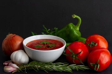 Tomato sauce in a white bowl surrounded by its ingredients: tomato of the 