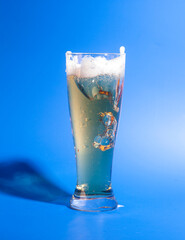 Glass with beer on blue background