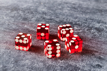 Five red glass dices on gray background, close-up