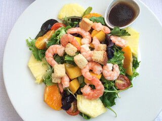 salad with shrimps, cherry tomatoes, thinly sliced ​​pineapple, orange, peaches, croutons, lettuce. Lisbon, Portugal