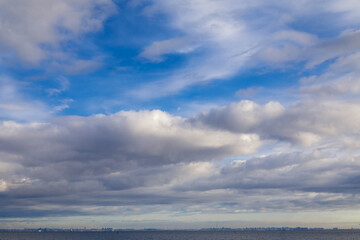 background from the blue sky with thick clouds and a line of sea below.