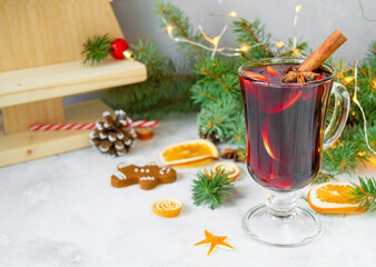  Сhristmas hot mulled wine with carnation, cinnamon, cardamom and anise on wooden background with Christmas decorations. New Year drinks.