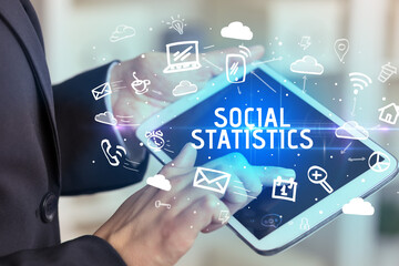 Close-up Of A Person Using Social Networking with SOCIAL STATISTICS inscription