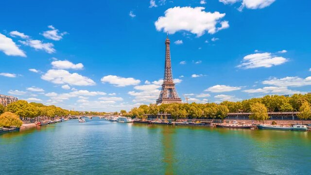 A timelapse of the Eiffel Tower along the river Seine with flyboats passing by with motion blur.Sunny but cloudy autumn day with golden yellow leaves,paris city riverside bay view bridge panorama