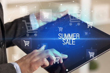 Young person makes a purchase through online shopping application with SUMMER SALE inscription