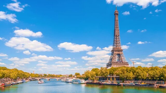 A timelapse of the Eiffel Tower along the river Seine with flyboats passing by with motion blur.Sunny but cloudy autumn day with golden yellow leaves,paris city riverside bay view bridge panorama
