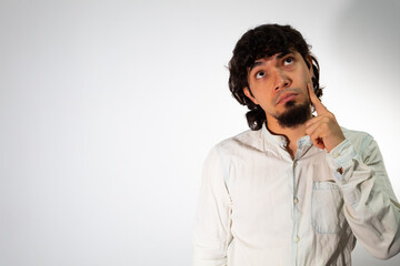 Young Hispanic man wearing casual clothes on a white background with thoughtful and pensive face