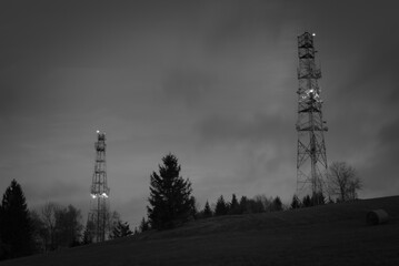 Mroczne ujęcie wież stacji bazowych telefoni komórkowej (B&W) - obrazy, fototapety, plakaty