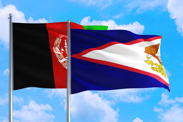American Samoa and Afghanistan national flag waving in the wind on a deep blue sky together. High quality fabric. International relations concept.