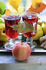 Warming drink, fruits, autumn leaves, spices on a wooden table against the background of a window, the concept of a healthy lifestyle, home comfort
