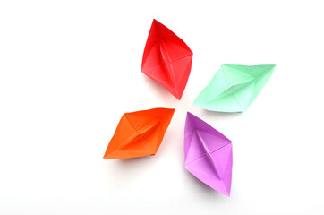 four colorful origami boats on white