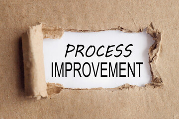process improvement, text on white paper on torn paper background