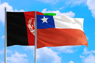 Chile and Afghanistan national flag waving in the wind on a deep blue sky together. High quality fabric. International relations concept.