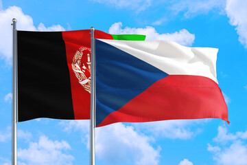 Czech Republic and Afghanistan national flag waving in the wind on a deep blue sky together. High quality fabric. International relations concept.