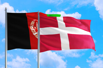 Denmark and Afghanistan national flag waving in the wind on a deep blue sky together. High quality fabric. International relations concept.