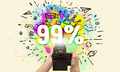 Close-up of a hand holding digital camera with abstract drawing and 99% inscription