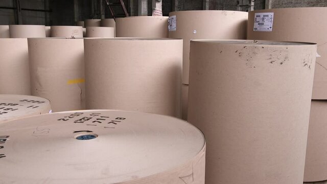 Cardboard and paper factory. Many rolls of paper are in the factory warehouse.