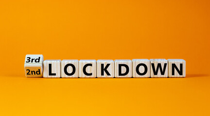 Symbol for a second or third lockdown. Turned a cube and changed the expression '2nd lockdown' to '3rd lockdown'. Beautiful orange background. Medical and covid-19 pandemic concept, copy space.