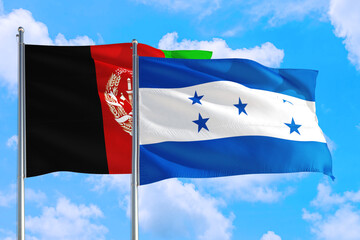 Honduras and Afghanistan national flag waving in the wind on a deep blue sky together. High quality fabric. International relations concept.