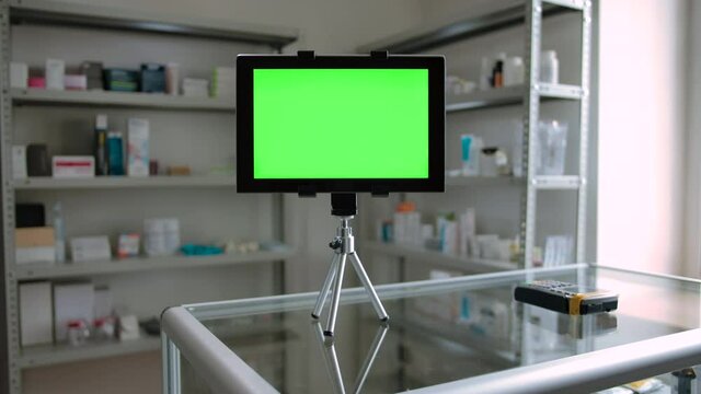 Green screen tablet PC dolly in shot indoor of pharmacy. Track and replace display for Your content on digital pad on mini tripod.