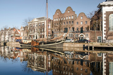 Schiedam, The Netherlands, November 7, 2020: the Jenevermuseum (gin museum), adjacent building and a historic barge reflecting in Long Harbour canal