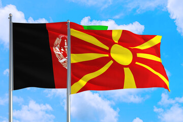 Macedonia and Afghanistan national flag waving in the wind on a deep blue sky together. High quality fabric. International relations concept.