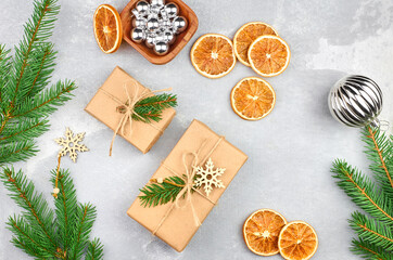 Fototapeta na wymiar Christmas gift boxes with dry orange slices and green fir tree branches