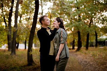 young couple flirting and hugging each other, outdoor candid lifestyle portrait