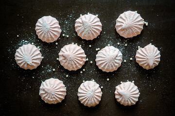 Pink marshmallow on a dark background. White and pink sweet homemade marshmallows or zephyr. The view from the top. Selective focus