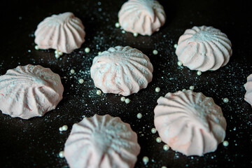 Pink marshmallow on a dark background. White and pink sweet homemade marshmallows or zephyr. The...